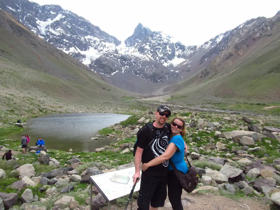 Pareja de excursionistas junto a una laguna de montaña en el Cajón del Maipo