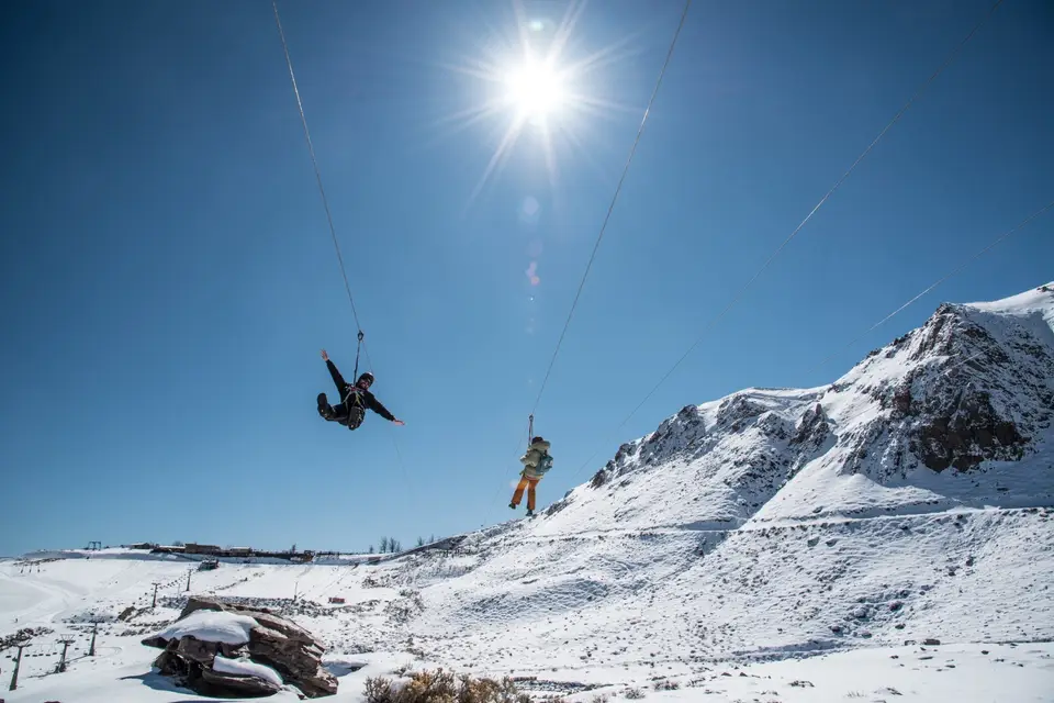 Persona en tirolesa sobre la nieve en la cordillera de los Andes