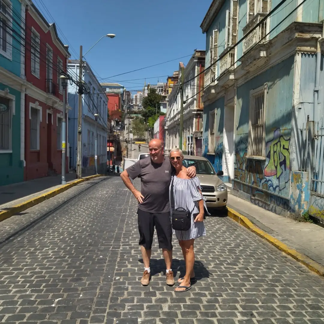 Couple on a street with graffiti and colorful houses in Valparaíso